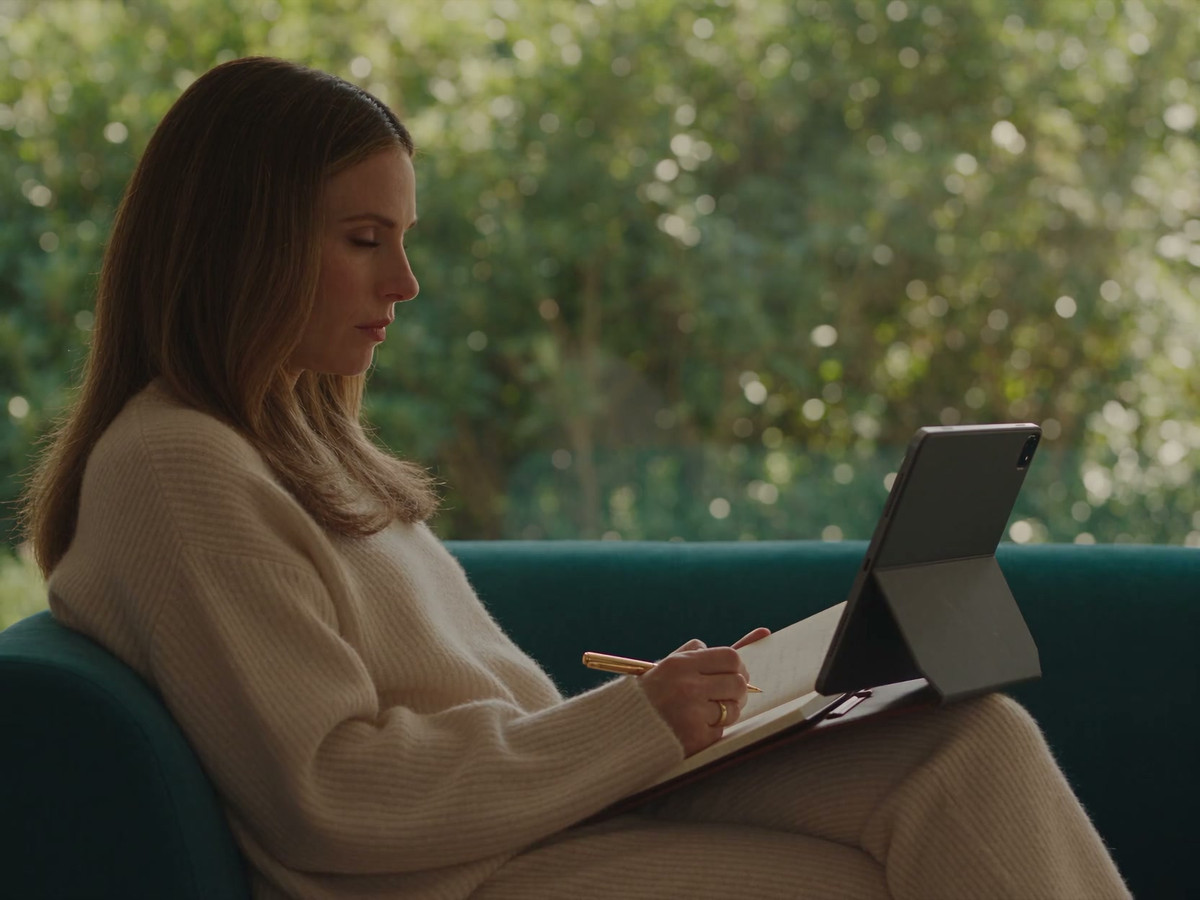 A practitioner reviews a statement on a supported tablet and notes a question