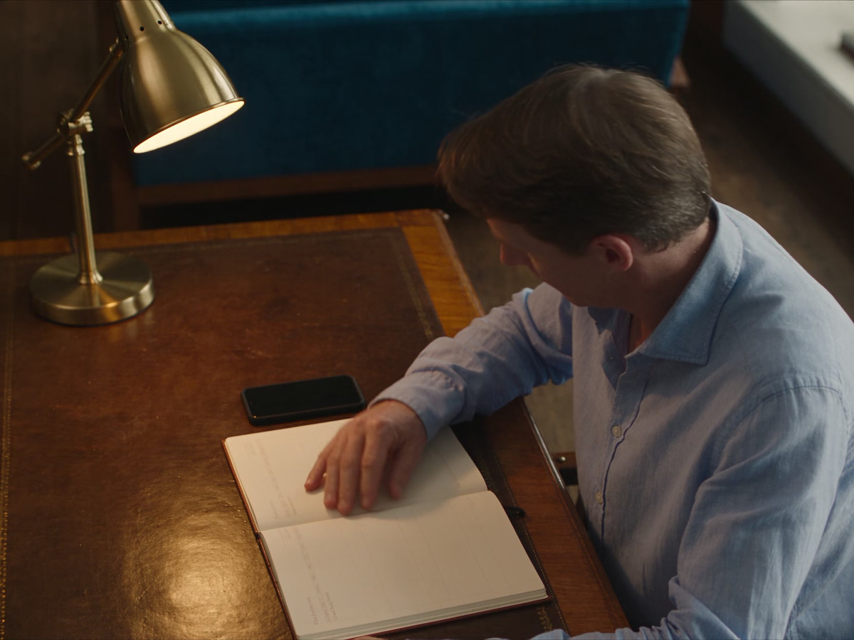 A gift-giver checks a diary before choosing a date on their phone