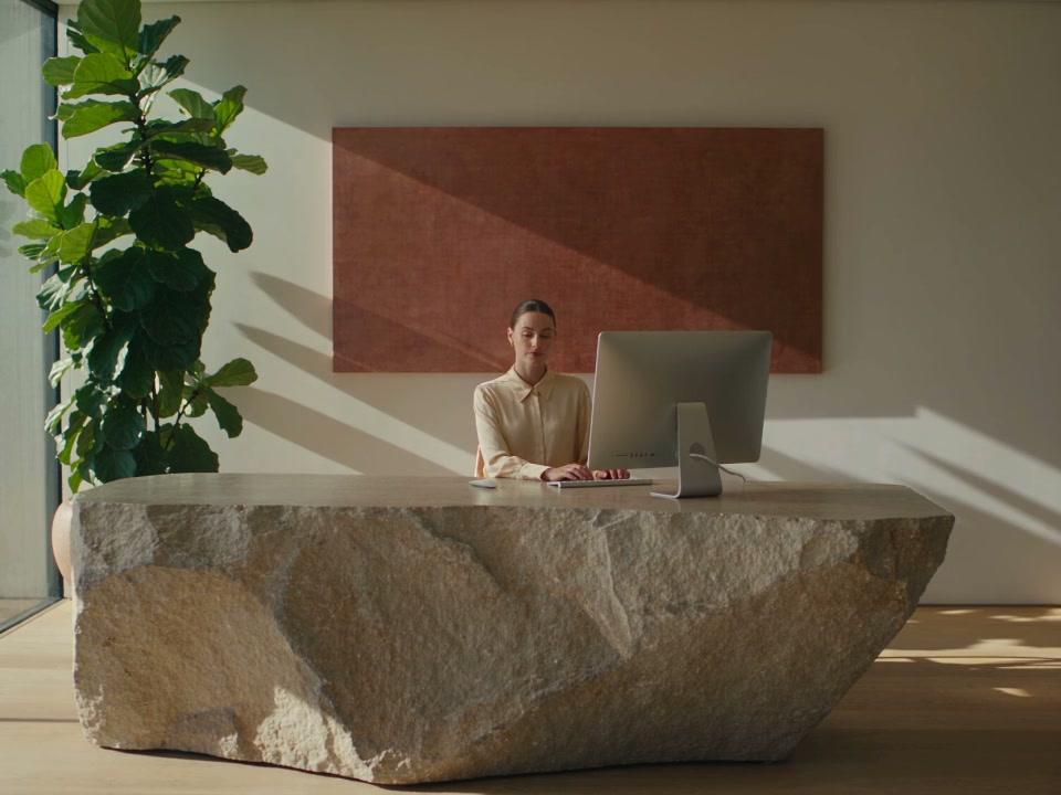 A receptionist works at a clinic front desk.