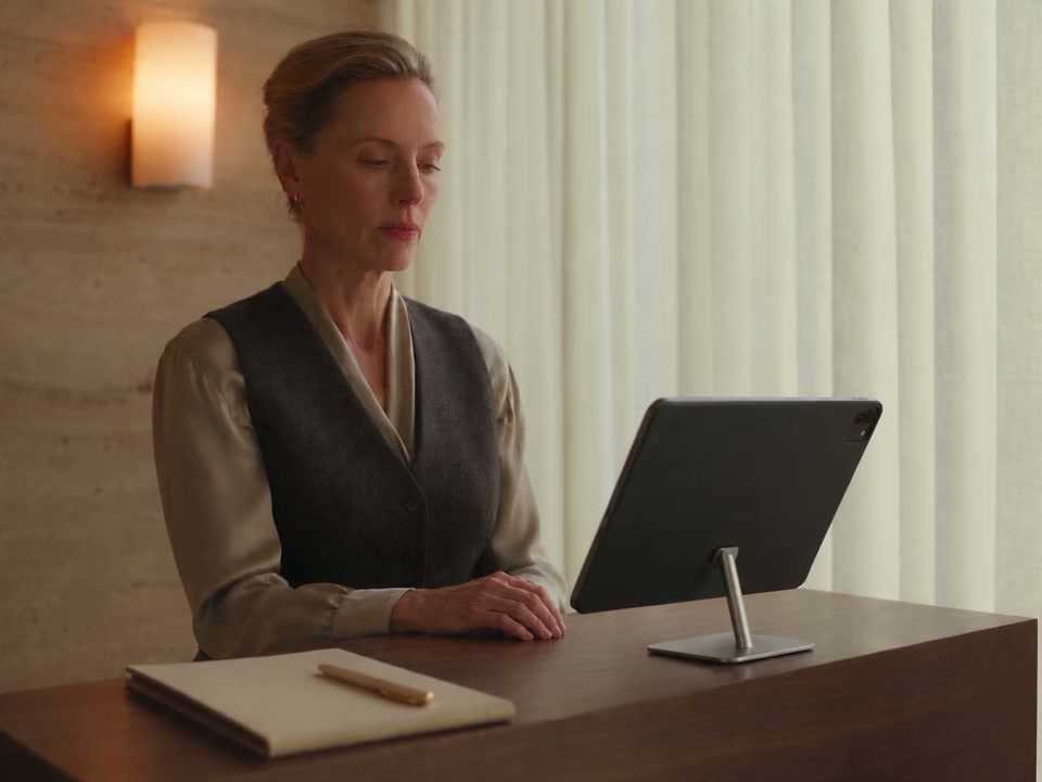 A practitioner sits alone reviewing information on a supported iPad after the patient’s visit
