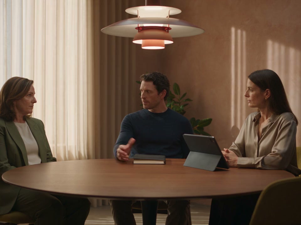 Clinic colleagues having a team conversation in a warm meeting room