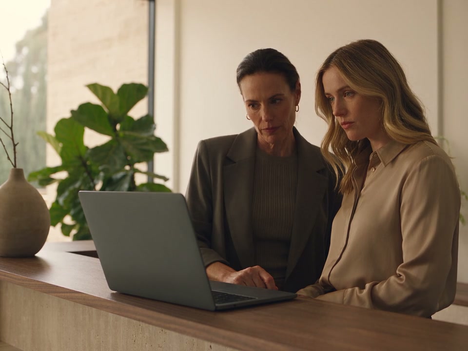Two clinic team members review outstanding work together at a computer