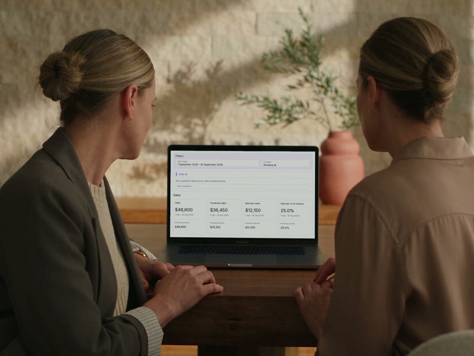 Clinic colleagues reviewing treatment and skincare sales on a laptop